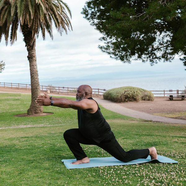 Person stretching gently outdoors in a park at sunrise.